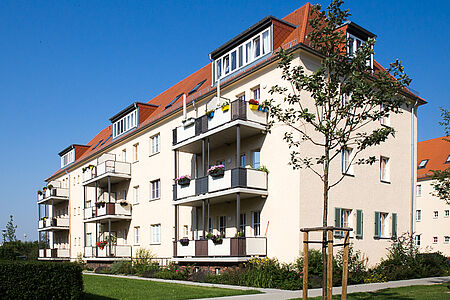 Saniertes Mehrfamilienhaus umgeben von einer Grünanlage