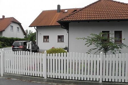 Einfamilienhaus und Garage mit schmutzig-weißer Fassade