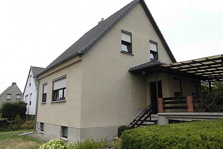 Mehrstöckiges Wohnhaus mit sanierungsbedürftiger Fassade in Erdtönen