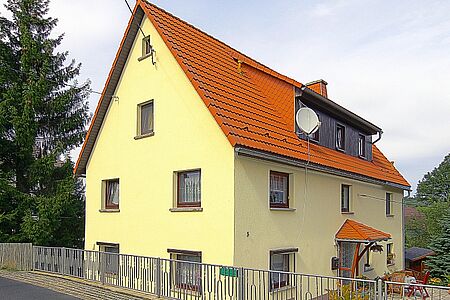 Wohnhaus mit vier Stockwerken und einer Fassade in Zitronengelb