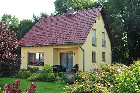 Einfamilienhaus mit gelber Fassade im Grünen