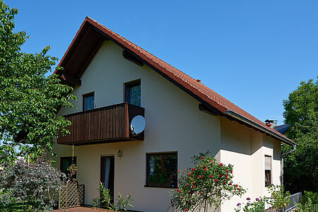 Weißes Wohnhaus nach der Sanierung mit SPS Spezialputzfassaden
