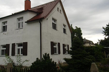 Großes, weißes Wohnhaus mit stark verschmutzter Fassade