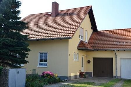 Modernes Einfamilienhaus mit Garagenanbau und hellgelber Fassade