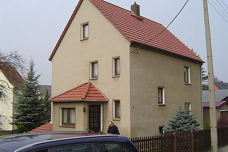 Beiges, schmales Einfamilienhaus mit drei Stockwerken vor der Sanierung mit FBS Fassadenbeschichtung