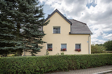 Villa mit Erkerdach und pastellgelber Fassade