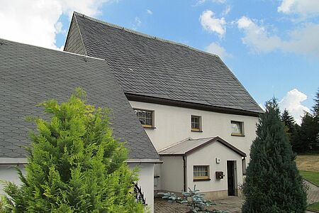 Weißes Einfamilienhaus mit fleckiger Fassade