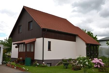 Wohnhaus mit dunkler Holzvertäfelung und frischer weißer Fassade