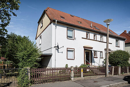 Mehrstöckiges Wohnhaus mit frischer, weißer Fassade