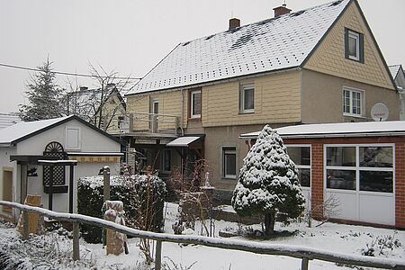 Dreistöckiges Wohnhaus mit vertäfelten Elementen an der Fassade
