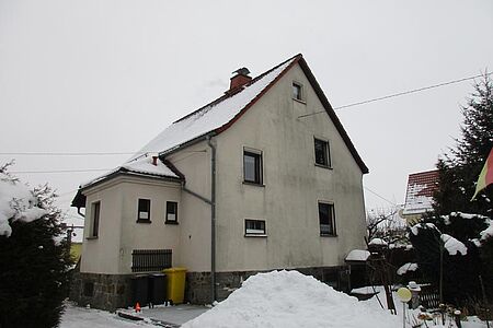 Wohnhaus mit drei Etagen und beiger, stark verschmutzter Fassade 