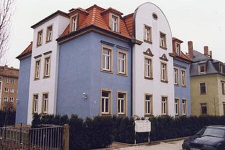 Mehrfamilienhaus mit Fassade in Weiß und Taubenblau