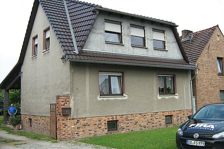 Ungestrichenes Einfamilienhaus mit grauem Putz
