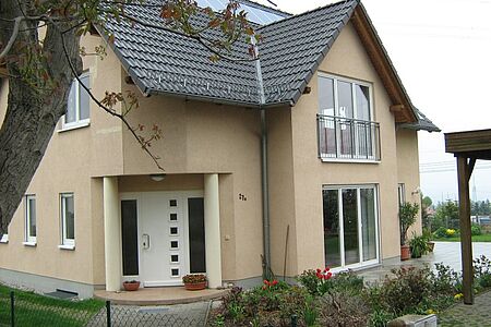 Großes Wohnhaus mit bodentiefen Fenster und helloranger Fassade