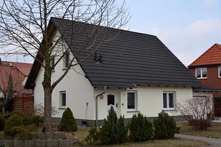 Weißes Einfamilienhaus mit schwarzem Dach