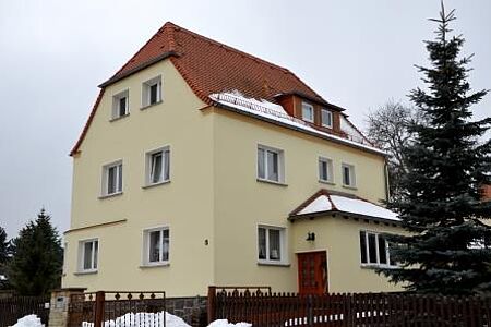 Dreistöckige Villa mit Krüppelwalmdach und pastellgelber Fassade