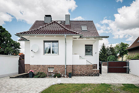 Einfamilienhaus mit verklinkertem Fundament und strahlend-weißer Fassade