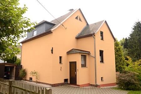 Grundsanierte Fassade eines großen Hauses in sanftem Safrangelb