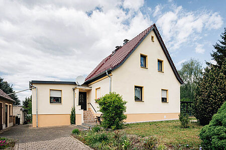 Einfamilienhaus mit frischer Fassade in sehr hellem Pastellgelb und Apricot