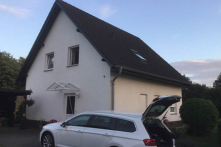 Weißes Einfamilienhaus mit leicht verschmutzter Fassade 