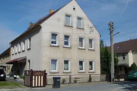 Mehrfamilienhaus mit vielen Fenstern und hellgrauer Fassade