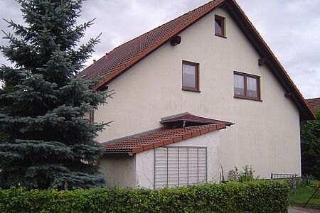 Weißes Einfamilienhaus mit verschmutzter Fassade