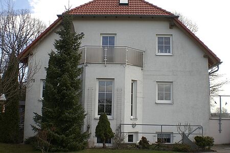 Villa mit einer Fassade in verschmutztem Weiß