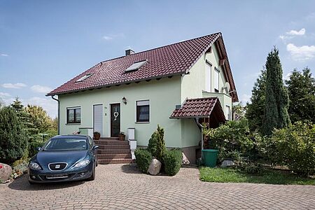 Hellgrünes Einfamilienhaus nach der Sanierung