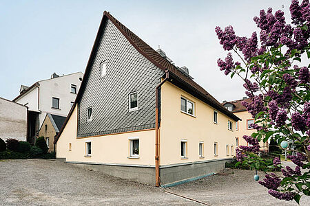 Großes Wohnhaus mit pastelloranger Fassade und vertäfelten Elementen