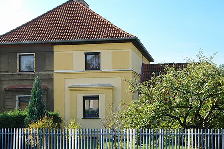 Haus mit Walmdach und zweifarbiger Fassade in Gelb und Braun