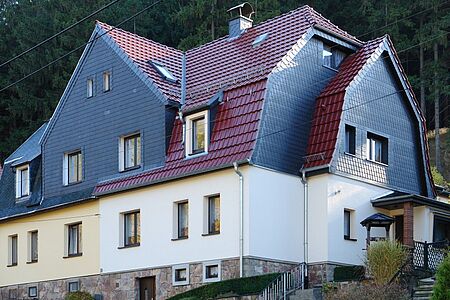 Mehrfamilienhaus am Berg mit Mansarddach nach der Fassadensanierung