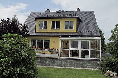 Gelbes Wohnhaus mit Garten, Wintergarten und veralteter Fassade