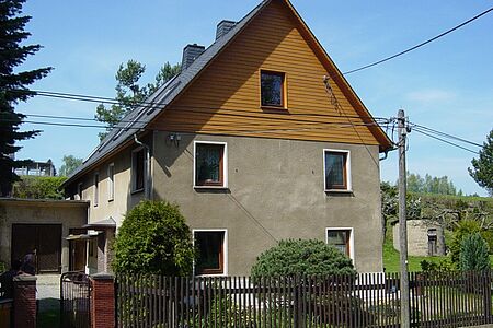 Braunes Wohnhaus mit vertäfelter Fassade des Dachgeschosses