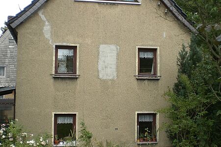 Braunes Haus mit großen Flecken auf der Fassade