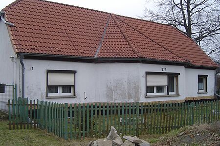 Zweistöckiges Wohnhaus mit sanierungsbedürftiger, stark verschmutzter Fassade