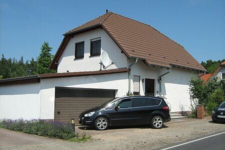Wohnhaus mit Garage und schmutzig-weißer Fassade