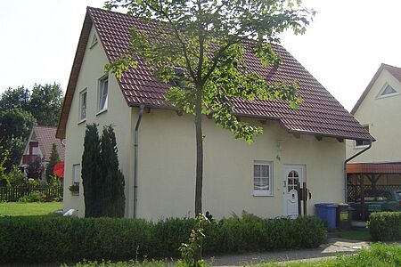 Pastellgelbes Einfamilienhaus mit leicht verschmutzter Fassade