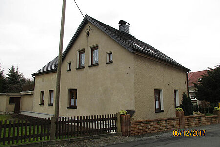 Großes Wohnhaus mit beige verputzter Fassade ohne Anstrich