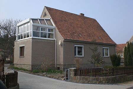 Graues Haus mit verglastem Balkon
