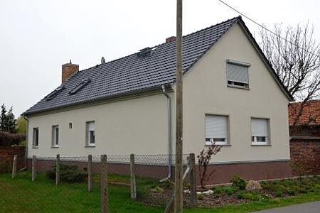 Langes Wohnhaus mit hellbeiger Spezialputzfassade