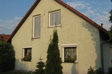 Wohnhaus mit bröckelnder Fassade in hellem Grün