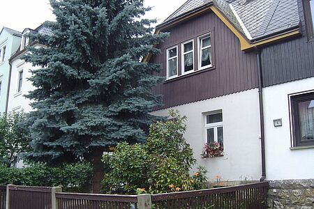 Großes Wohnhaus mit veralteter, weißer Fassade