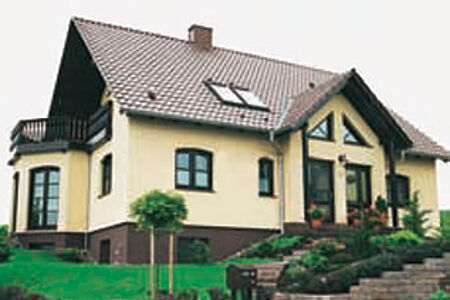 Einfamilienhaus mit gelber Fassade, braunem Fundament und braunem Ziegeldach