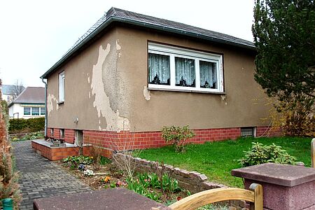 Braunes Bungalow mit bröckelnder Fassade