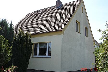 Wohnhaus mit stark verschmutzter ehemals weißer Fassade im Erdgeschoss 