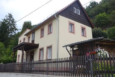 Helles Einfamilienhaus mit pastellfarbenen Akzenten an Fenstern