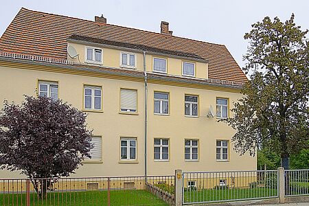 Mehrfamilienhaus mit einheitlicher Fassade in hellem Gelb