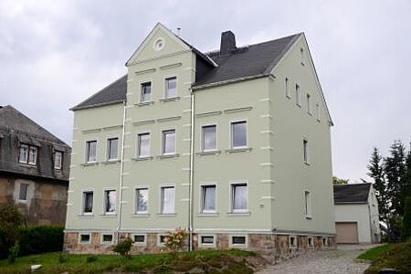 Traditionelles Mehrfamilienhaus mit moderner weißgrüner Fassade