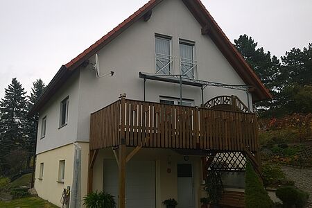 Helles Wohnhaus mit Holzbalkon