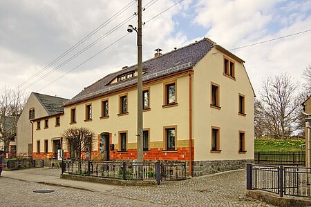 Reihenhaus mit frischem, pastellgelbem Anstrich und Walmdach